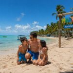 Família brincando em praia de água calma e clara no Brasil, em Maragogi.