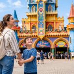 Mãe e filho caminhando em frente ao castelo do Beto Carrero World durante um passeio em família com crianças.